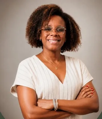 Agatha Barbosa, de braços cruzados e sorrindo